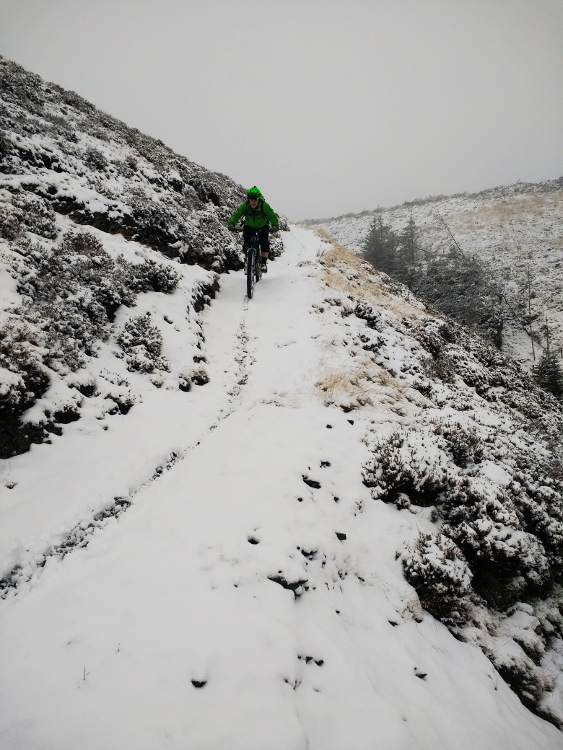 A mountain biker riding the Trans Cambrian Way in a blizzard